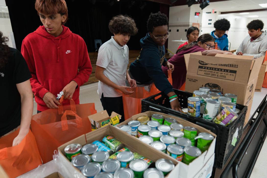 Students pack canned goods into bags