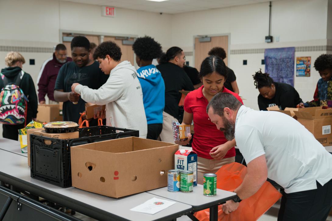 A group of students pack food into bags