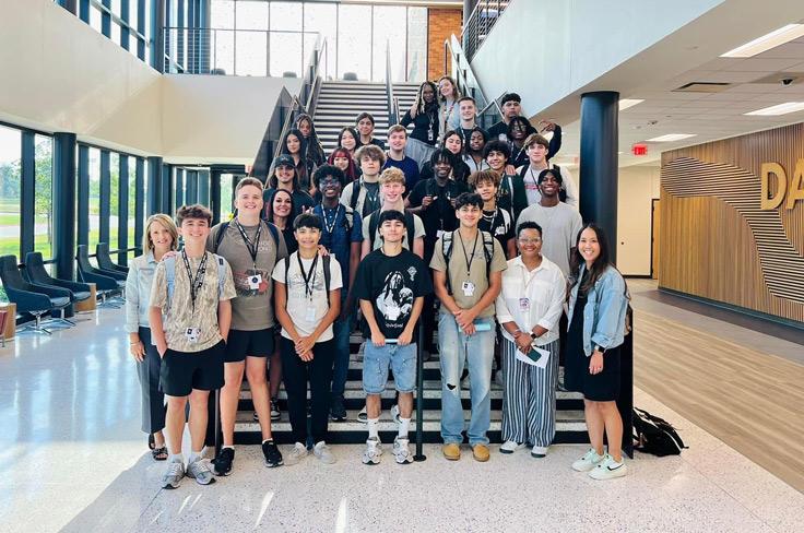 High school students and teachers pose on the stairs at Dallas College.