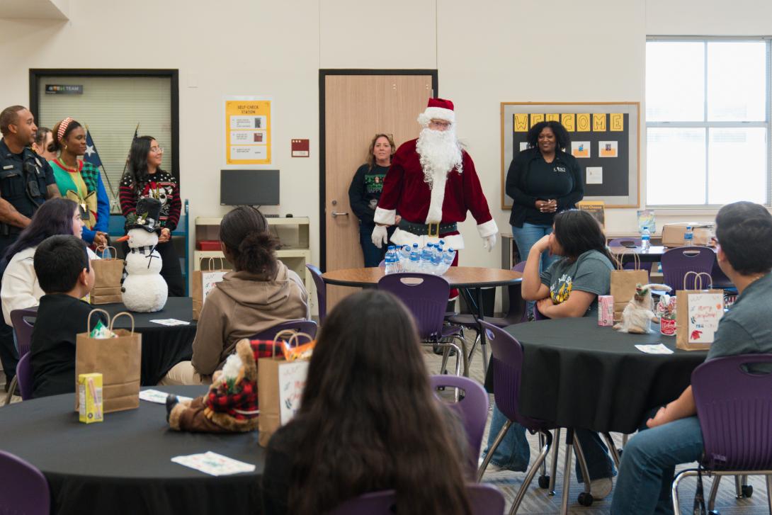 Man dressed as Santa addresses group of students