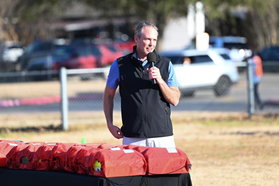 USL Dallas Founder stands near a table with gift bags