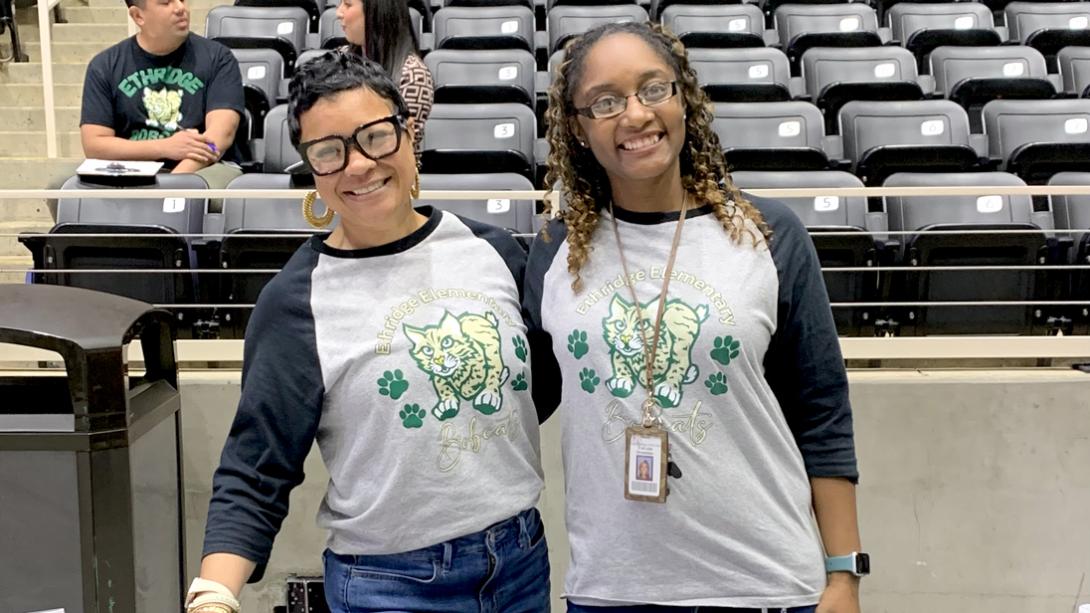 Two smiling Ethridge ES staff members on the fair arena floor.