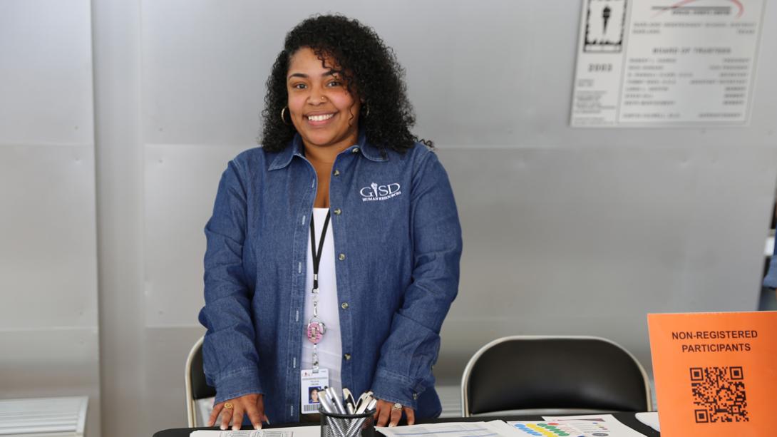 An HR employee smiles while manning the check in table.