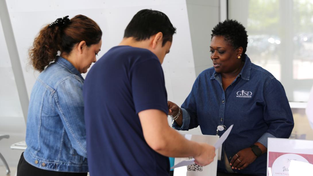 An HR member helps candidates with paperwork.