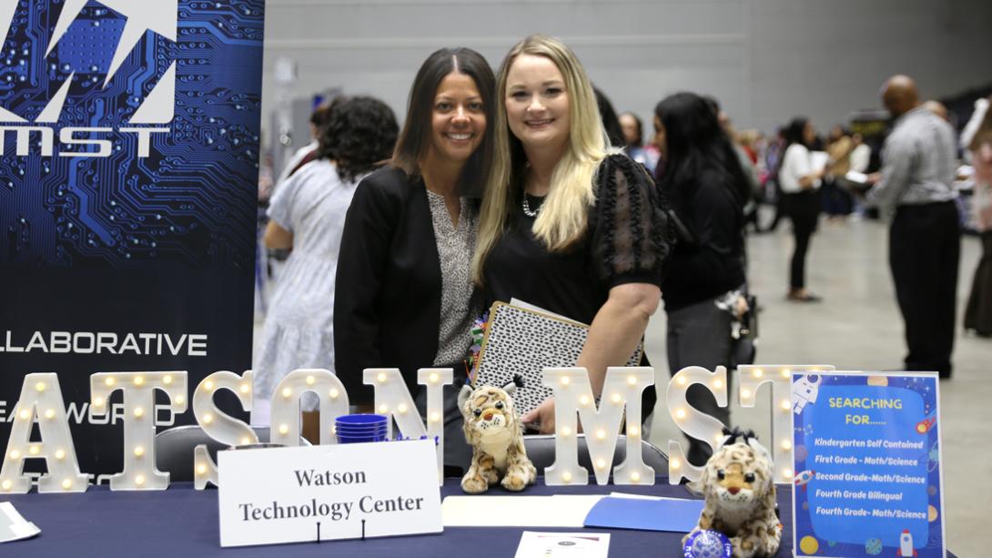 The Watson MST Principal and Assistant Principal smile for a photo at their table.
