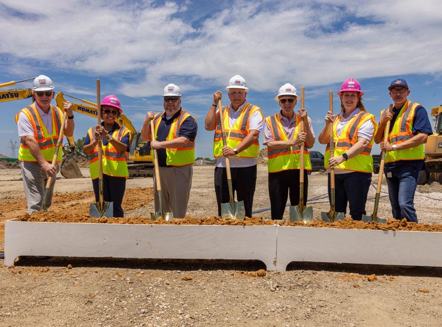Board with hard hats and helmets ready for the ceremonial groundbreaking for  Sachse High School Multi-program Activity Center