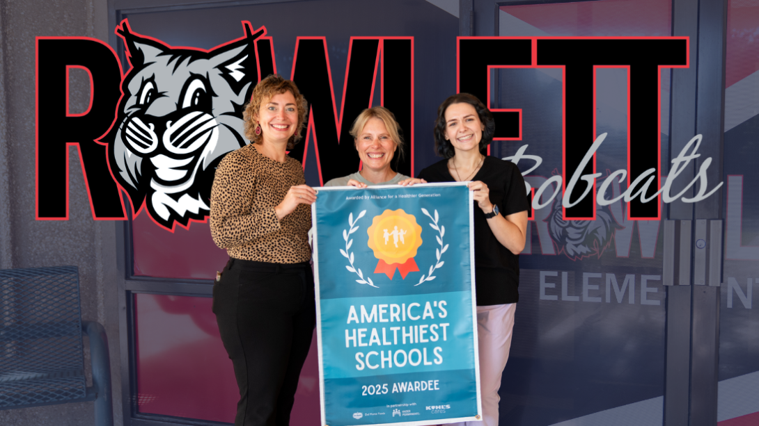 A group of three women stand with a banner that reads "America's Healthiest Schools"