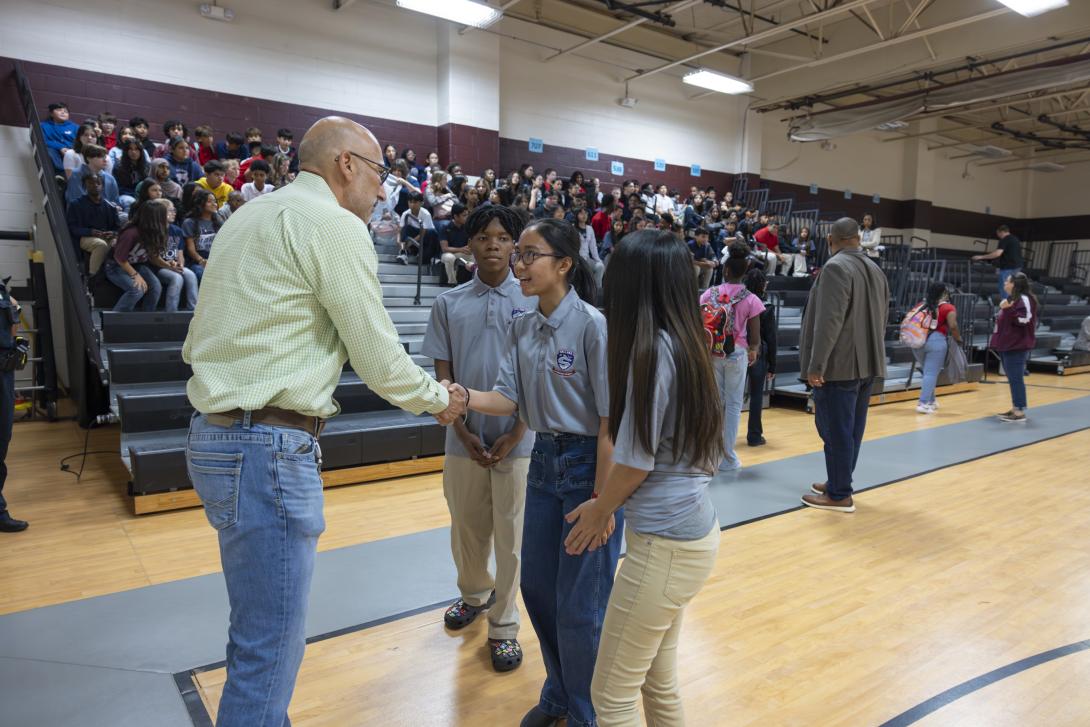 Dr. Lopez speaks to a small group of three diverse students