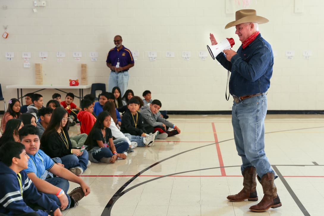 Man dressed as Big Texas speaks to students