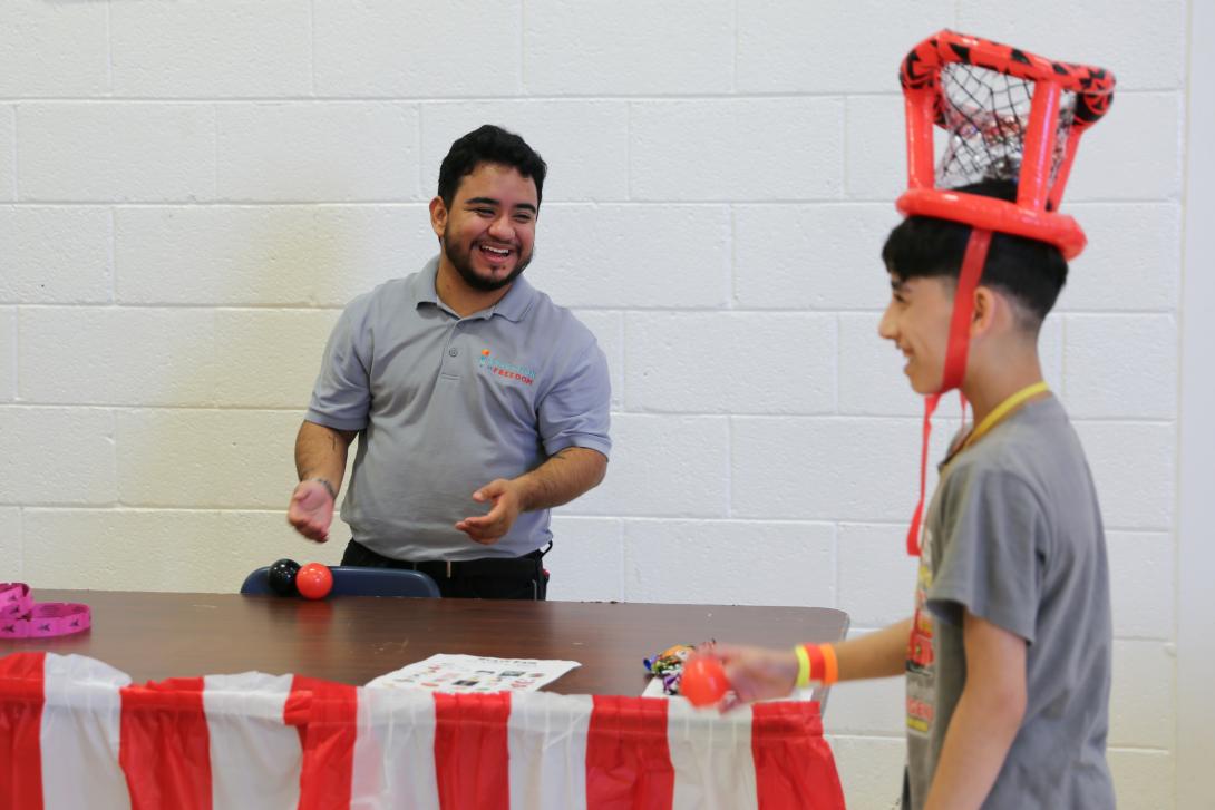 Student and teacher play a basket toss game