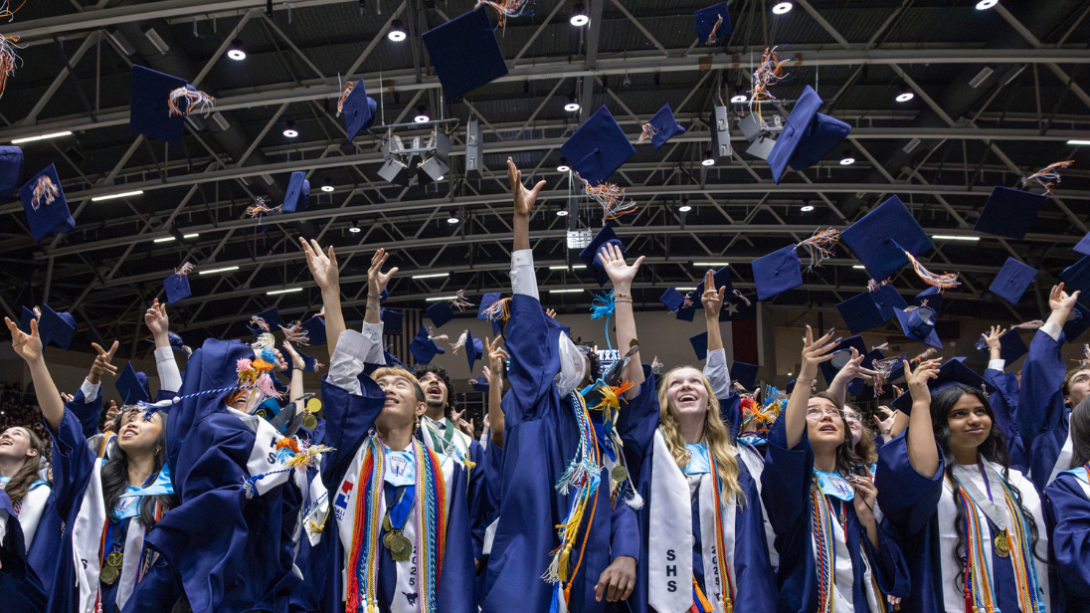 students throw their graduation caps in the air