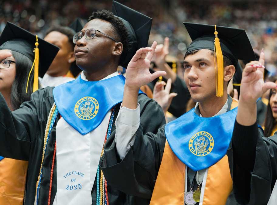 Two young men at graduation ceremony wearing Collegiate Academy collars with their cap and gown.