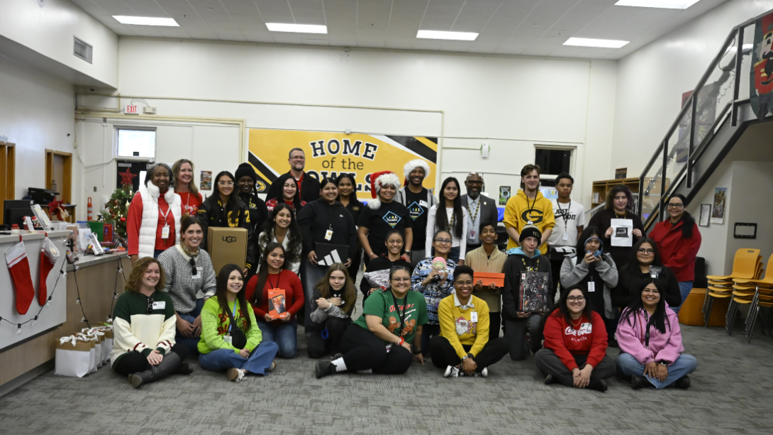 Students and staff pose for a photo with some people seated and some standing