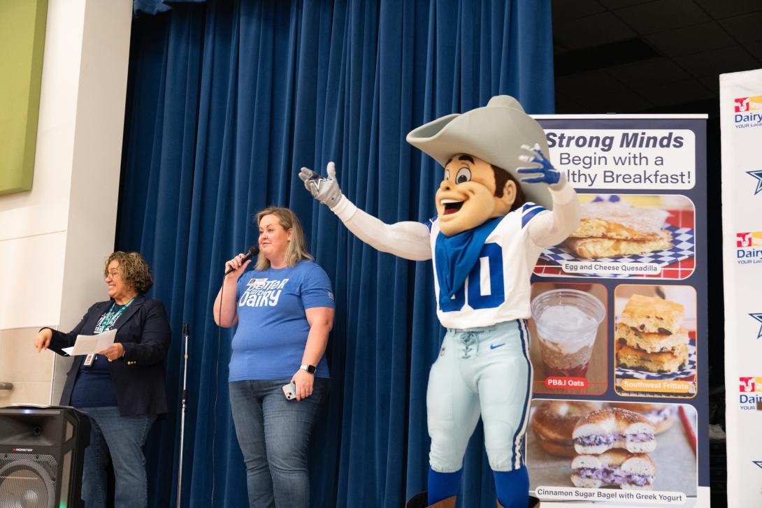 Dallas Cowboys mascot stands on stage with two adults