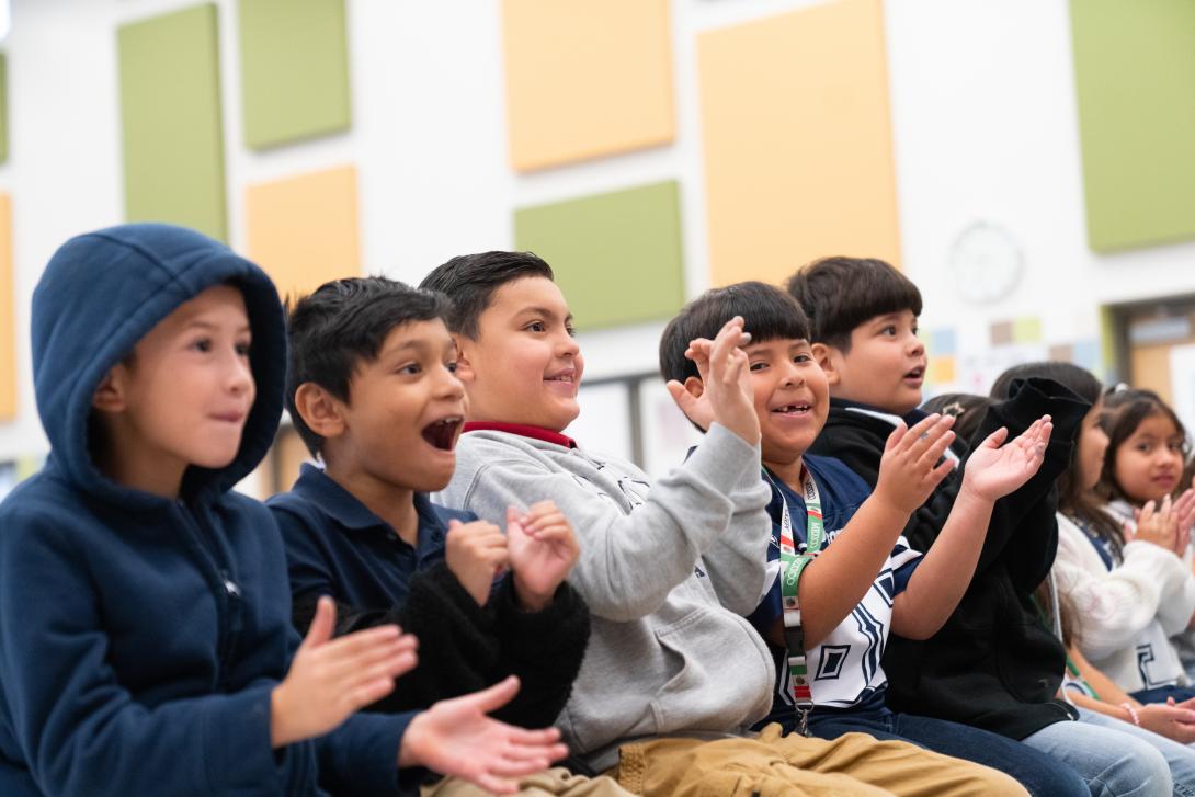 A group of students cheer as they look ahead