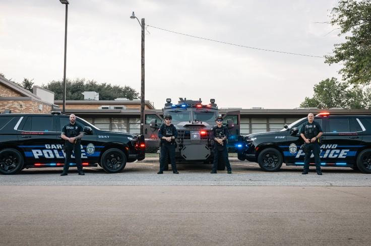 Police standing in front of police cars in front of Training Center
