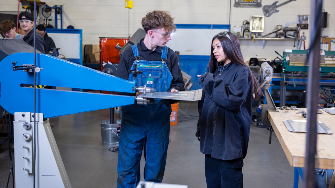 Two students hold a metal sheet 