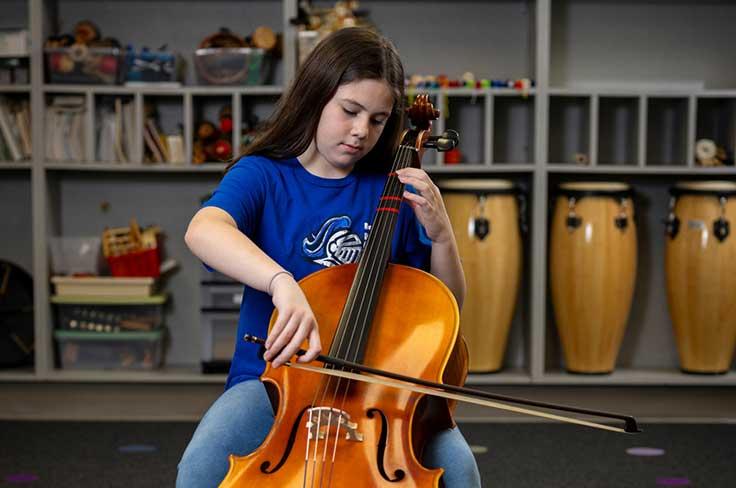 Girl playing cello in music room