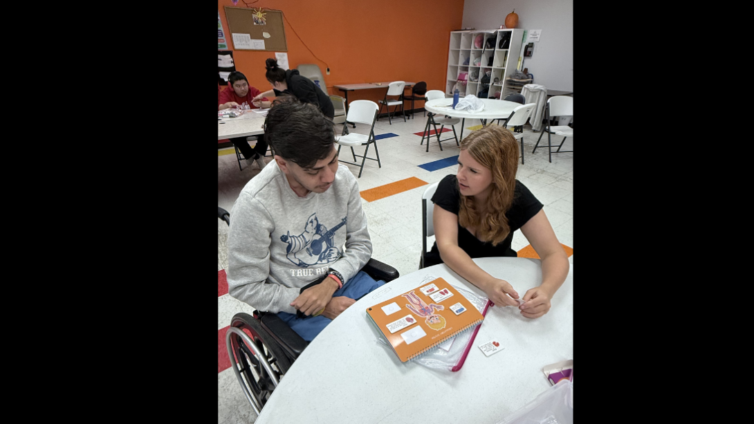 a female student works with a special needs adult
