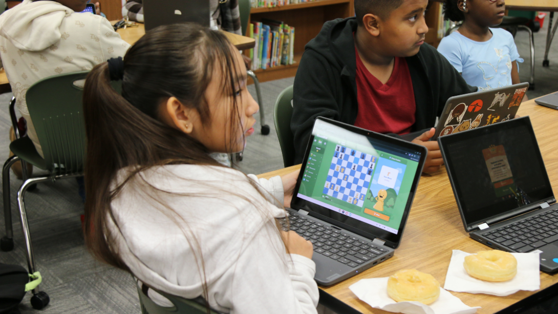female student plays chess on chromebook device