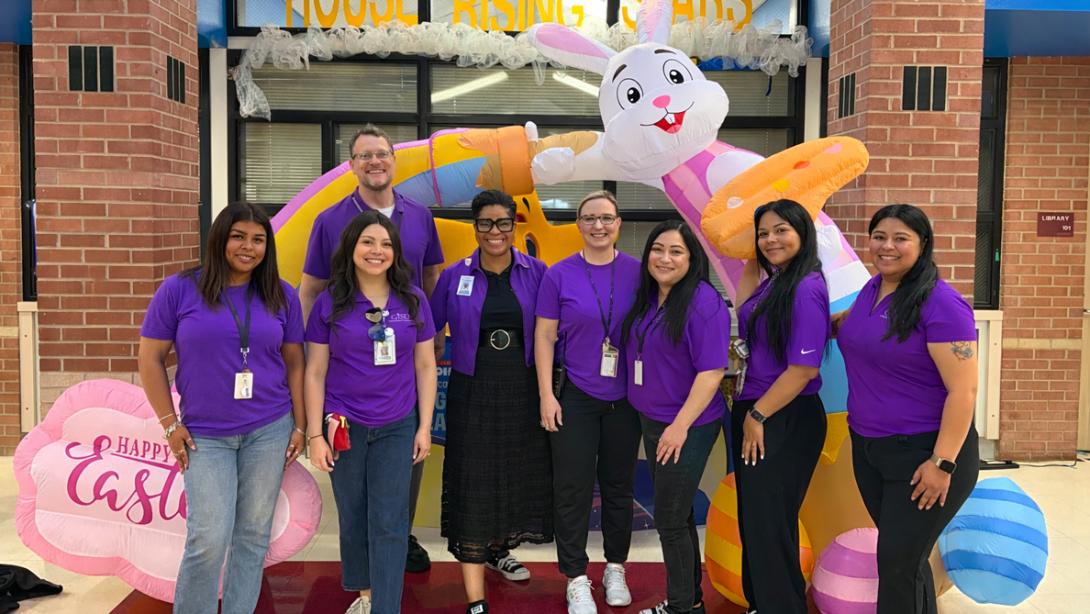 The student services team pose together in purple honoring military children.
